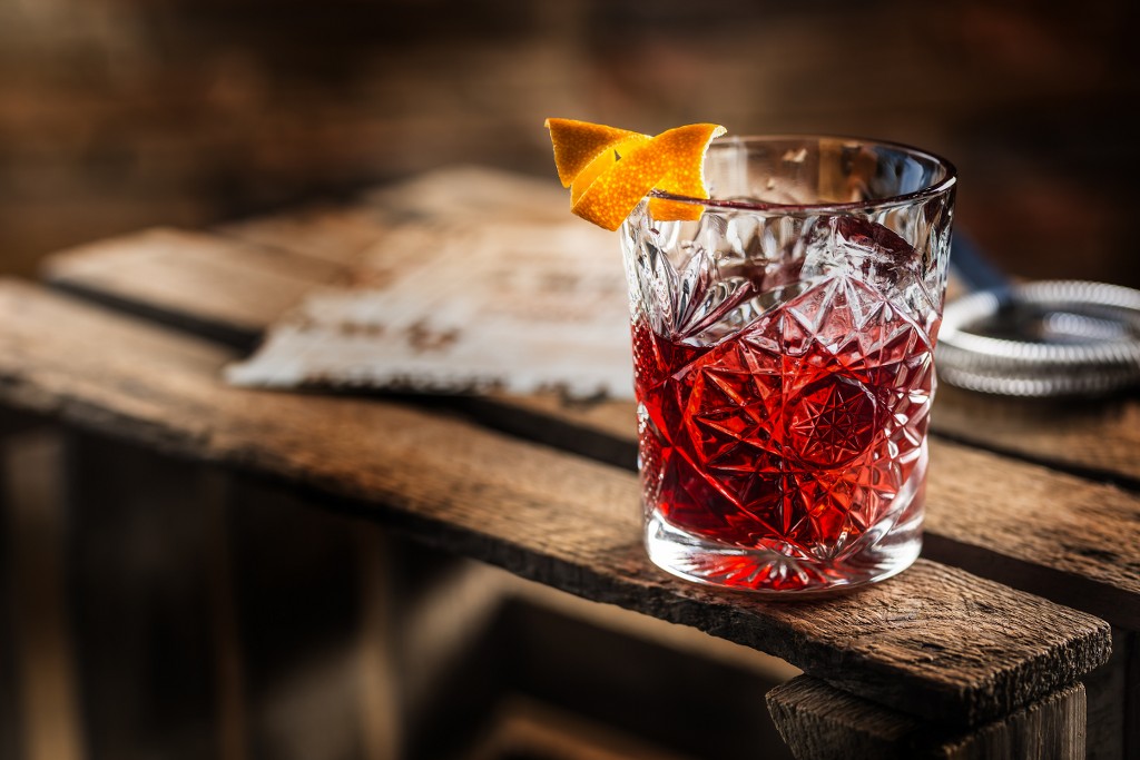 cocktail-negroni-su-una-vecchia-tavola-di-legno-da-bere-con-gin-campari-martini-rosso-e-arancia