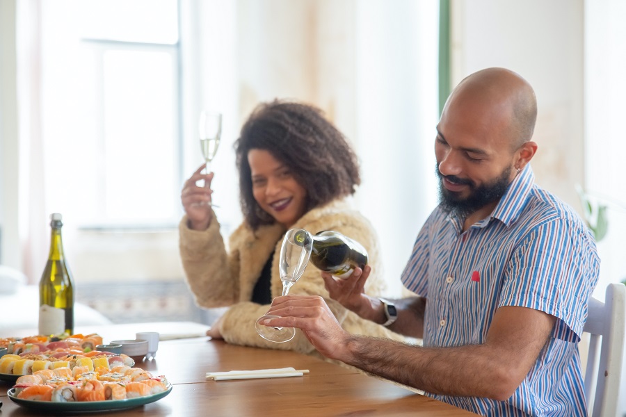 coppia che beve spumante e mangia sushi